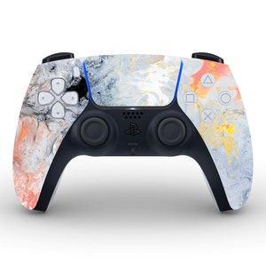 Peut inclure: Une manette de jeu PlayStation 5 blanche, noire et orange avec un motif marbré.