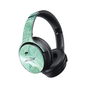 May include: A pair of black over-ear headphones with a green marble pattern on the earcups and headband. The headphones have a Bose logo on the earcup.