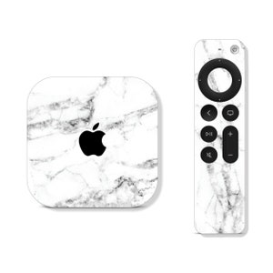 May include: White marble skin decal for Apple TV 4K and remote. The decal features a white marble pattern with gray veining. The Apple logo is visible on the Apple TV decal.