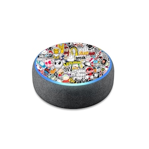 May include: A black Amazon Echo Dot smart speaker with a colorful sticker design featuring various logos and characters, including Superman, Coca-Cola, and Grand Theft Auto. The speaker has a blue light ring around the top.