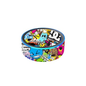 May include: A round, blue and black speaker with a colorful sticker design. The stickers feature various graphics, including a cartoon character, a skateboard brand logo, and the words "My Team".