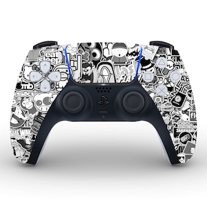 May include: A white and black PlayStation 5 DualSense controller with a sticker design. The controller has a variety of black and white stickers with different designs, including cartoon characters, logos, and text.