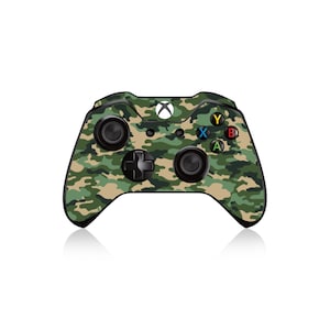 Może przedstawiać: Kontroler Xbox z wzorem kamuflażu, czarnymi przyciskami i białym logo Xbox.
