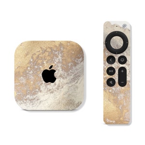 May include: A white and gold Apple TV 4K with a black Apple logo and a matching white and gold remote control.
