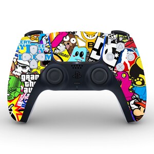 May include: A black PlayStation 5 DualSense controller with a colourful sticker design. The stickers feature various cartoon characters, logos, and text, including "Grand Theft Auto", "M.I.G.H.T.Y", and "DC Comics".