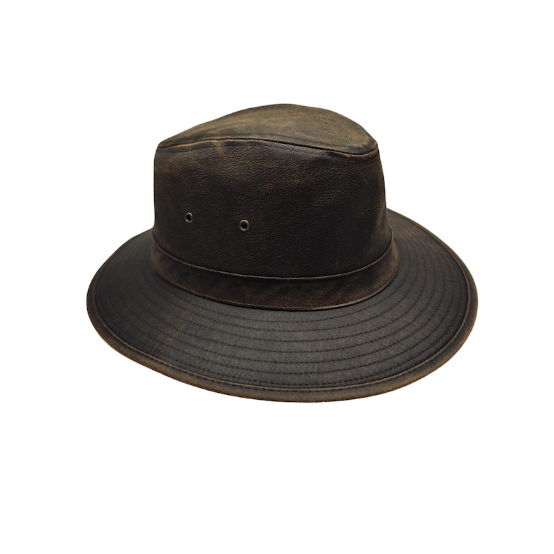 May include: A dark brown leather hat with a wide brim and a slightly distressed appearance. The hat features a structured crown with two small eyelets and a band around the base of the crown. The brim is stitched for durability.