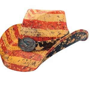 May include: Cowboy hat with a distressed American flag design in red, yellow, and black. The hat features a decorative metal buckle with an eagle emblem and a black band. A stylish accessory for a patriotic look.