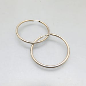 May include: A pair of silver hoop earrings. The hoops are simple and classic, with a smooth finish.