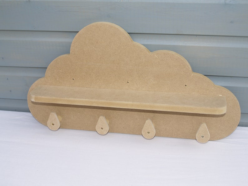 May include: A wooden cloud-shaped shelf with a small shelf and four hooks. The shelf is unfinished and ready to be painted or stained.
