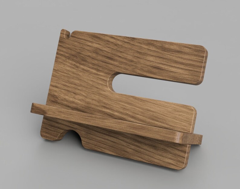 May include: A wooden phone stand with a shelf for charging or holding a phone. The stand is made of light brown wood with a natural grain pattern.