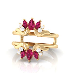 Pode incluir: Um realçador de anel dourado com um design floral. O realçador apresenta pedras preciosas rosa-escuras em forma de pêra e pequenas pedras preciosas brancas redondas. O anel tem duas bandas e um topo decorativo com detalhes curvos.