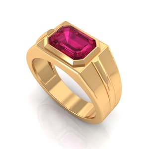 Può includere: Un anello d'oro con una pietra preziosa rettangolare rosa intenso. L'anello ha una fascia in oro lucido con un design geometrico attorno alla pietra preziosa. La pietra preziosa è incastonata in una lunetta e l'anello ha uno stile classico ed elegante.