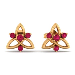 Può includere: Un paio di orecchini a lobo in oro con un design traforato ispirato alla triquetra. Ogni orecchino è impreziosito da quattro pietre preziose rotonde di un vivido rosso rosato, incastonate al centro e sulle tre punte della montatura.