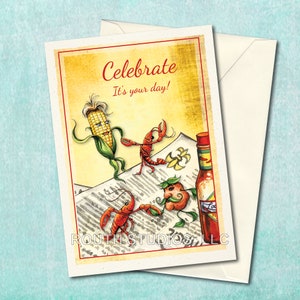 May include: A greeting card with a yellow background and the text "Celebrate It's your day!"  The card features a cartoon corn cob, two cartoon crawfish, and a bottle of hot sauce.