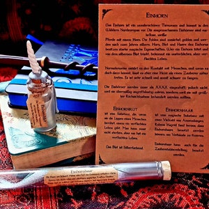 Könnte beinhalten: Zwei Glasfläschchen mit Einhornblut und -haar, sowie eine Textkarte, die die magischen Eigenschaften jedes einzelnen beschreibt. Die Karte ist braun mit weißem Text und trägt den Titel "Einhorn".