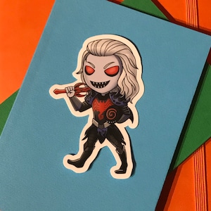 May include: A sticker of a cartoon character with long white hair, red eyes, and sharp teeth. The character is wearing a black and red costume with a red weapon in their hand. The character is standing on a blue background.