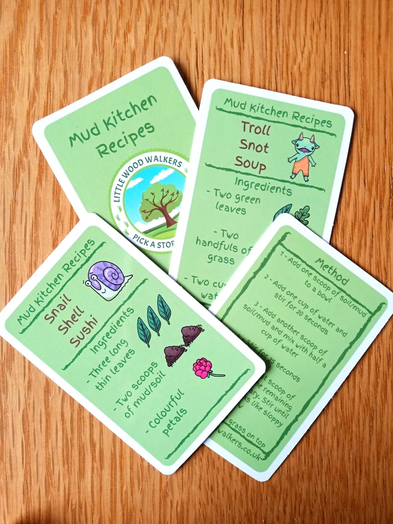 May include: Four green recipe cards with illustrated images and text. The cards are for a game called "Mud Kitchen Recipes" and feature recipes for "Troll Snot Soup", "Snail Shell Sushi", and two other recipes. The cards are made by Little Wood Walkers.