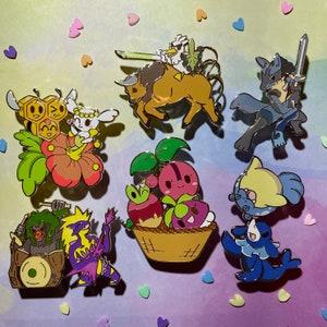 Peut inclure: Un ensemble de dix &eacute;pingles en &eacute;mail repr&eacute;sentant diff&eacute;rents personnages de dessins anim&eacute;s. Les &eacute;pingles sont color&eacute;es et pr&eacute;sentent une vari&eacute;t&eacute; de th&egrave;mes, notamment des animaux, des plantes et de la nourriture.