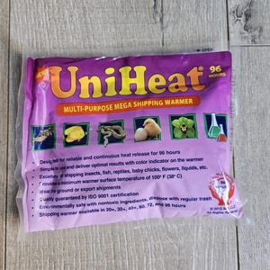 May include: Purple and white packaging for a UniHeat 96-hour multi-purpose mega shipping warmer. The packaging shows images of insects, fish, reptiles, baby chicks, flowers, and liquids. The text on the packaging reads "UniHeat 96 hours Multi-Purpose Mega Shipping Warmer".