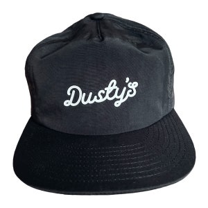May include: Black and black-brimmed baseball cap with a white embroidered logo that says "Dusty's".