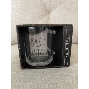 May include: A clear glass mug with a black handle and the text "BASIC WITCH" printed on the front. The mug is in a black box with the Rae Dunn logo.