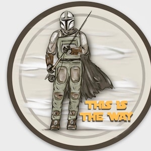 Puede incluir: Una pegatina redonda con una ilustración de dibujos animados de un personaje mandaloriano sosteniendo una caña de pescar. El fondo es de color marrón claro con un patrón de remolino blanco. El texto "This is the way" está impreso en naranja en la parte inferior de la pegatina.