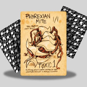 Puede incluir: Una carta de fantasía con una ilustración detallada de un Phyrexian Mite y el texto "TOXIC 1". La carta tiene un aspecto vintage con un fondo marrón y está flanqueada por dos cartas con patrones en blanco y negro.
