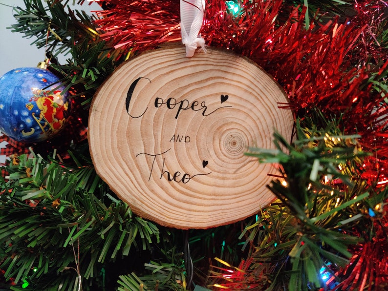 The back of a custom painted pet ornament, with the pets name written in cursive.