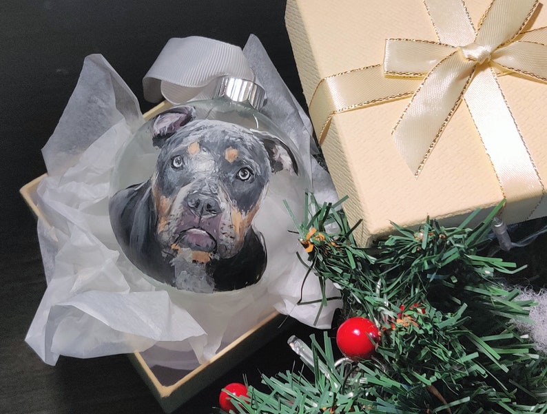 Custom painted pet glass ornament. Hand painted detailed realistic pet portrait on transparent round glass bauble ornament. 1 ornament shown, grey bulldog.