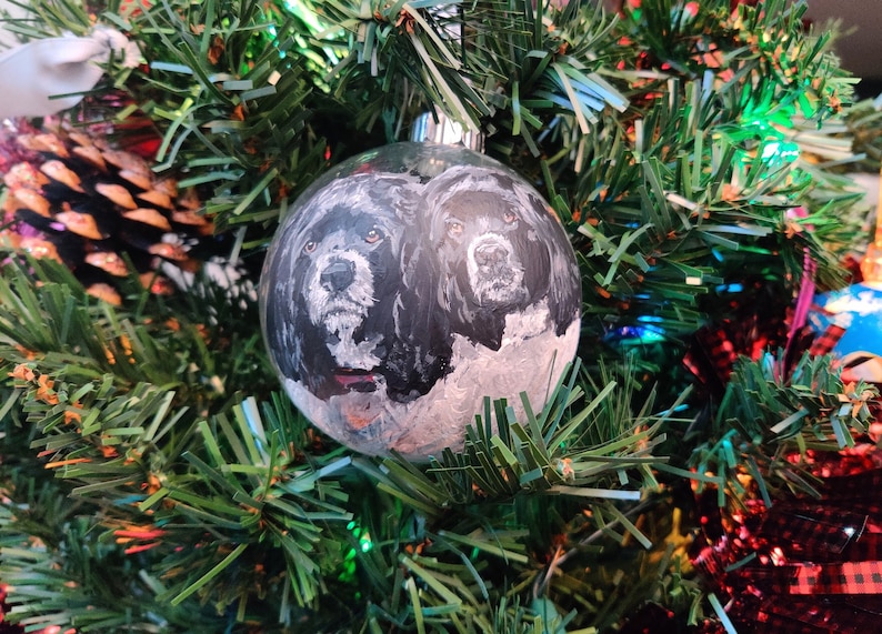 Custom painted double pet glass ornament. 2 hand painted detailed realistic pet portraits on a transparent round glass bauble ornament. 2 black and white poodles shown painted.