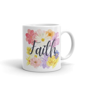 May include: White ceramic mug with a floral design and the word "Faith" in black script. The flowers are pink, yellow, purple, and white.