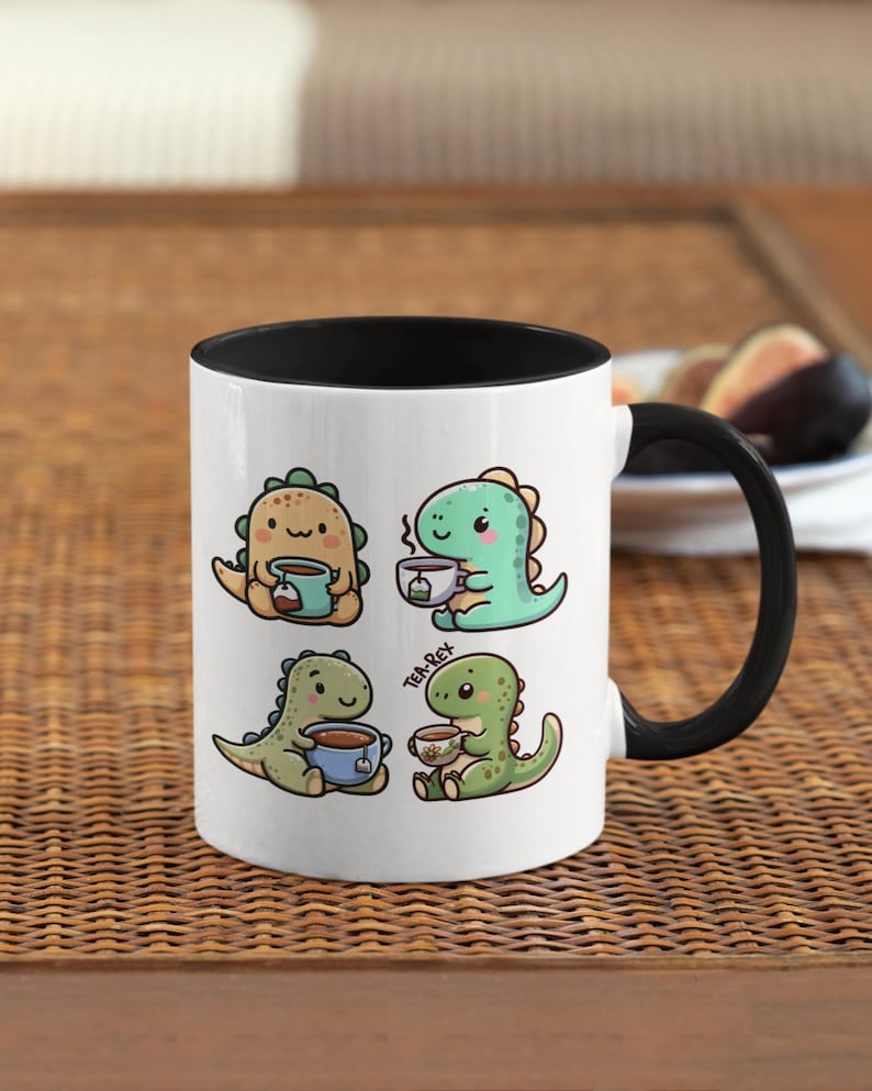 May include: White ceramic mug with a black rim and handle. The mug features a cartoon illustration of four dinosaurs drinking tea. The text "Tea-Rex" is printed on the mug.