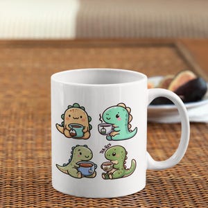 May include: White ceramic mug with a graphic of four cartoon dinosaurs drinking tea. The dinosaurs are green, yellow, and blue. The text "Tea-Rex" is printed on the mug.