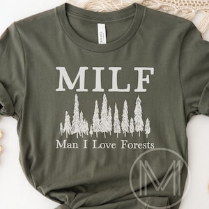 May include: A green t-shirt with the text "MILF Man I Love Forests" in white lettering. The text is surrounded by a row of white trees.