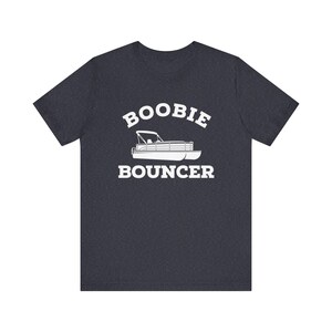 May include: A dark heather gray t-shirt with a white graphic of a pontoon boat and the text "Boobie Bouncer".