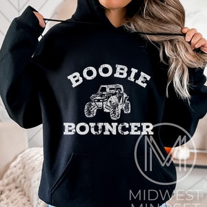 May include: Black hoodie with white text that reads "Boobie Bouncer" and a graphic of an off-road vehicle.