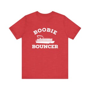 May include: Red heather t-shirt with white text that reads "Boobie Bouncer" and a white silhouette of a pontoon boat.