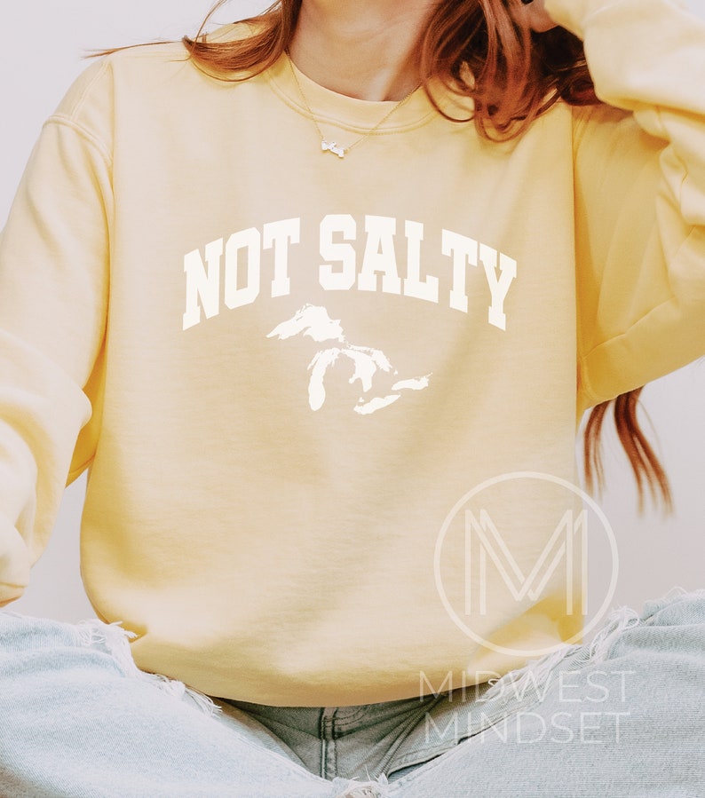 May include: A yellow sweatshirt with the text "NOT SALTY" in white, with a white outline of the Great Lakes.