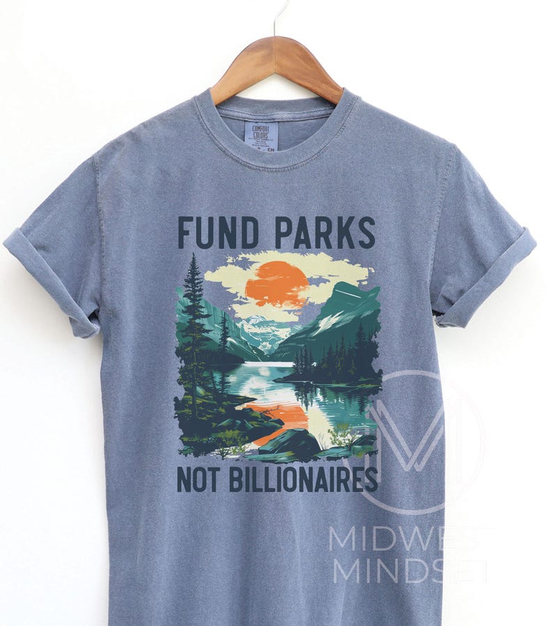 May include: A blue t-shirt with a graphic of a mountain landscape and the text "Fund Parks Not Billionaires".