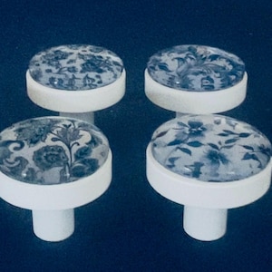 French blue and white cabinet knobs. Delft like graphic designs displayed under glass dome These are solid metal knobs not plastic, not wood