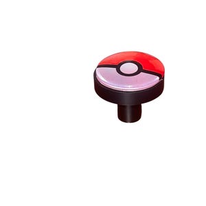May include: A red and white Pokeball-themed cabinet knob with a black base and stem. The knob features a glossy finish and a circular design, perfect for adding a touch of fun to any furniture piece.