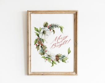 May include: A framed watercolor print with a white floral wreath and the text "Merry and Bright!" in red cursive.