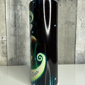 May include: A black and green stainless steel tumbler with a graphic of a character from the movie "The Nightmare Before Christmas". The character is holding a heart and the text "This is Halloween" is visible on the tumbler.