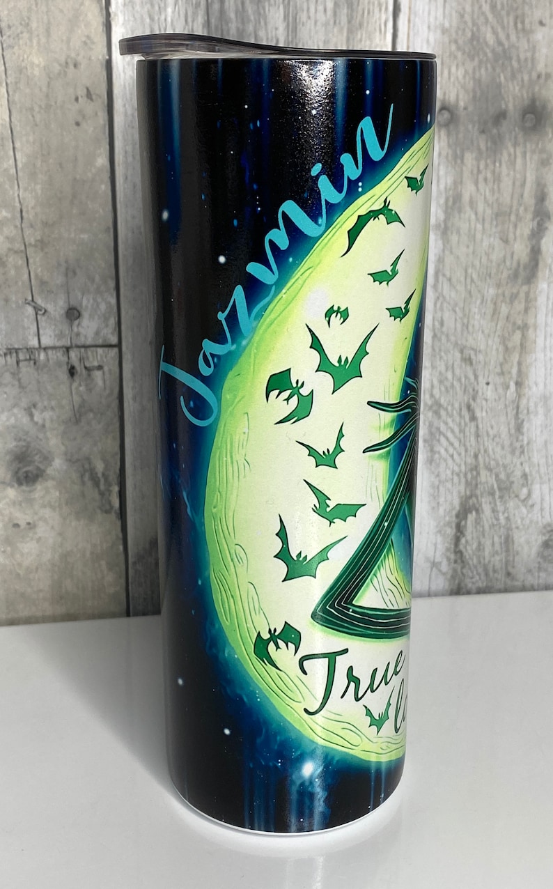 May include: A black and green stainless steel tumbler with a moon and bats design. The text "Jazmin" and "True Love" are printed on the tumbler.