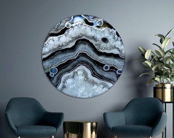 Könnte beinhalten: Ein rundes Wandbild mit einem schwarzen, weißen und blauen Achat-Design. Der Achat hat ein wirbelndes Muster mit weißen Kristallen und schwarzen Linien. Das Kunstwerk hängt an einer grauen Wand über zwei blauen Sesseln und einem goldenen Beistelltisch.