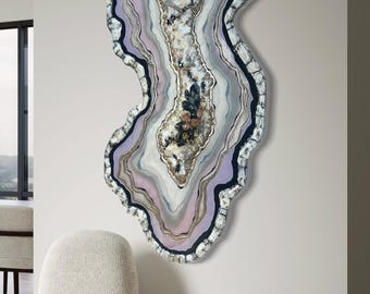 Könnte beinhalten: Abstrakte Wandkunst in Form einer Geode mit konzentrischen Farbschichten. Das Kunstwerk hat eine wellenförmige, unregelmäßige Form mit Lavendel-, Grau-, Weiß- und Goldtönen. Der äußere Rand ist strukturiert mit einem dunklen, gesprenkelten Rand.