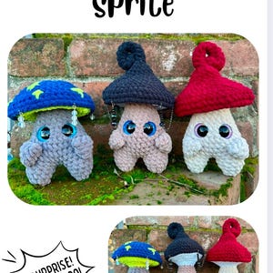 May include: Three crocheted mushroom plushies with different colored hats. The mushrooms are gray, beige, and white. The hats are blue with green stars, black, and red. The mushrooms are sitting on a green mossy surface. The text "Surprise! It pops too!" is in a speech bubble in the lower left corner of the image.