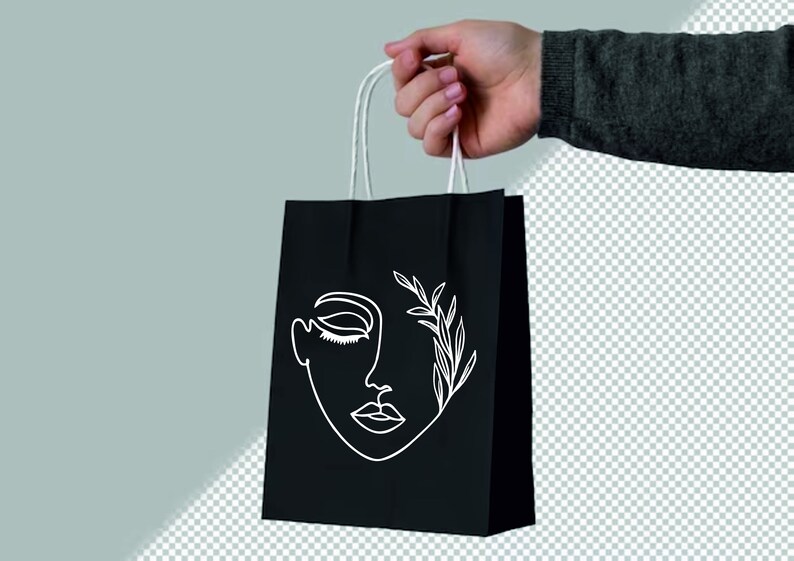 May include: A black paper shopping bag with white line art of a face and leaves. The bag has white handles.
