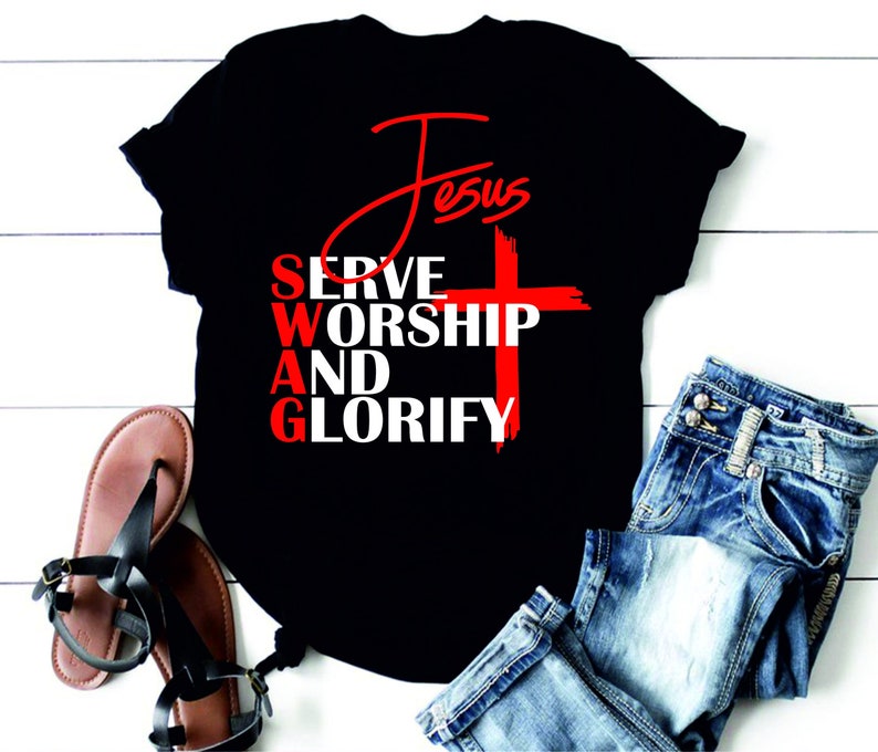 May include: Black t-shirt with red text that reads "Jesus" and "Serve Worship And Glorify" with a red cross in the middle.