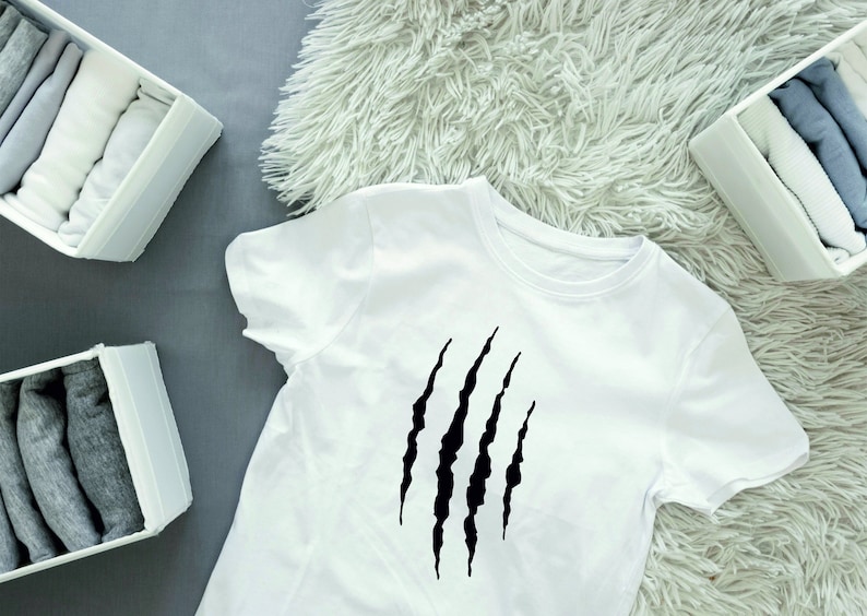May include: White t-shirt with a black claw mark graphic print.